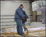 Foamseal applying spray foam insulation application to wall for demonstration.